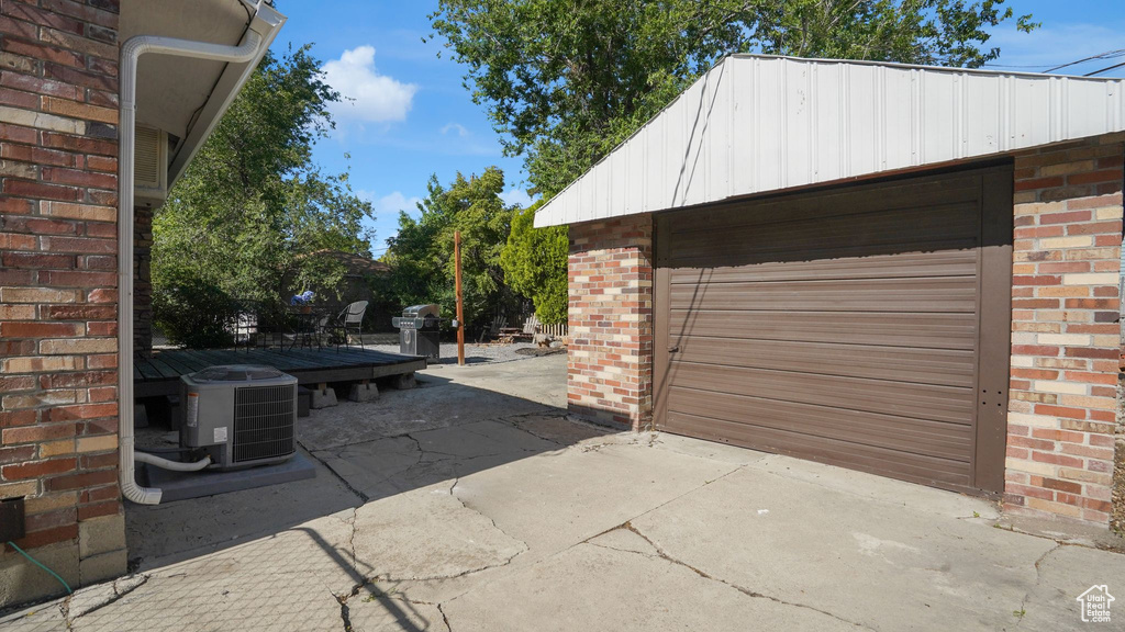 Garage with central air condition unit and concrete driveway
