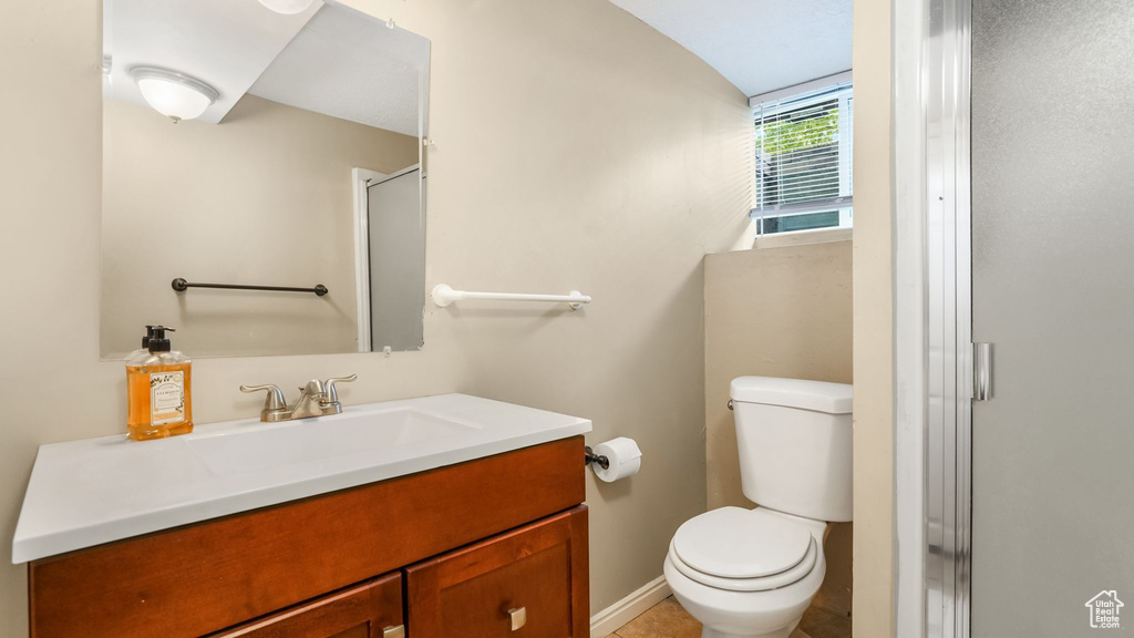 Full bath featuring vanity, toilet, and a stall shower