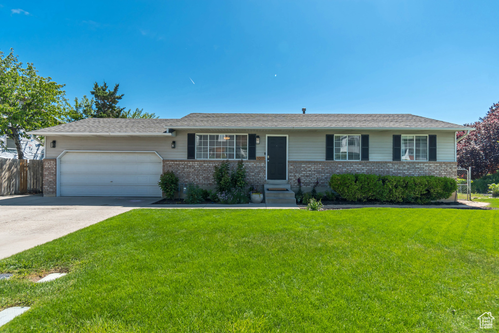 Ranch-style home with brick siding, an attached garage, and concrete driveway