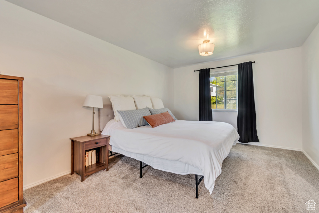 Bedroom featuring light carpet and baseboards