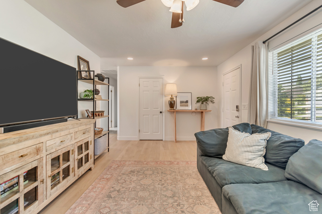 Living area with ceiling fan, light wood-style floors, recessed lighting, and baseboards