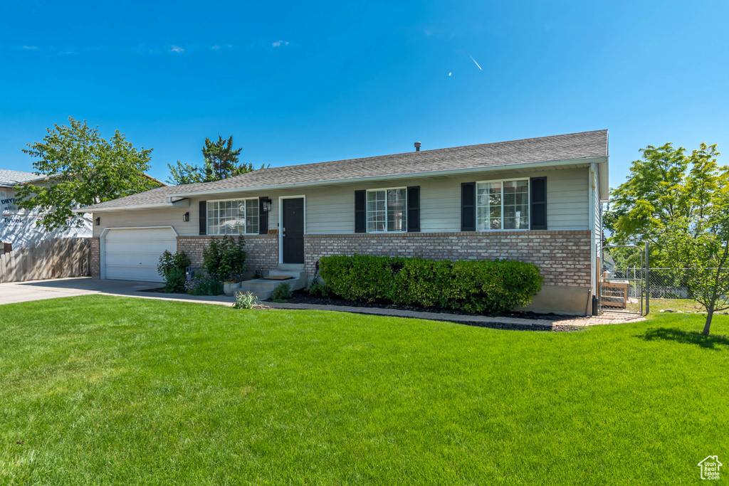 Ranch-style home featuring brick siding, driveway, and a garage