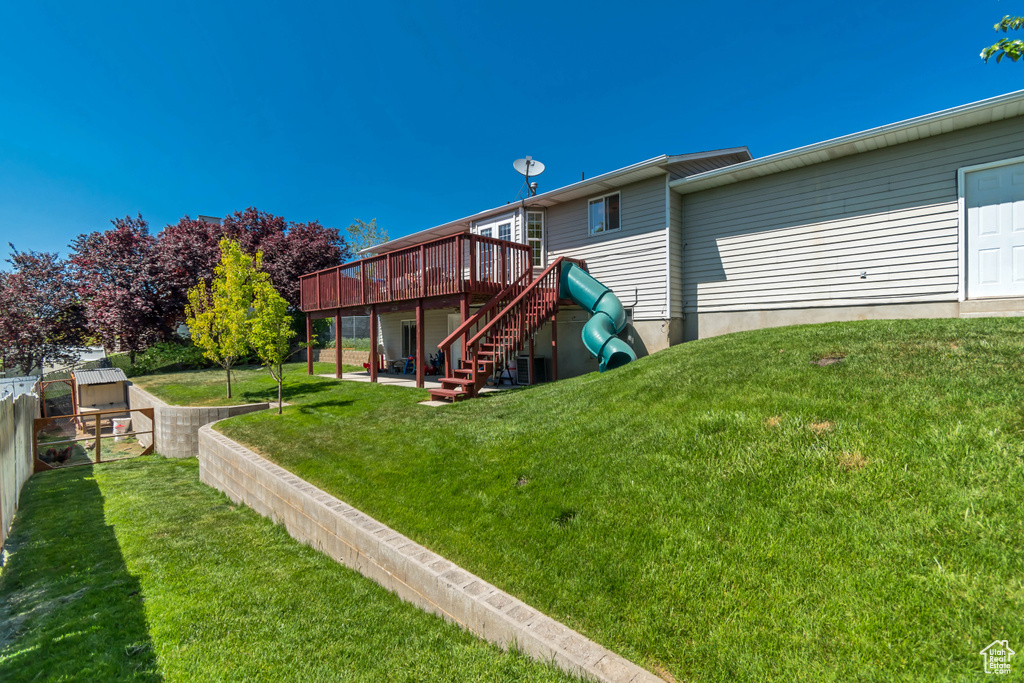 Rear view of house featuring a wooden deck, stairway, and a patio area