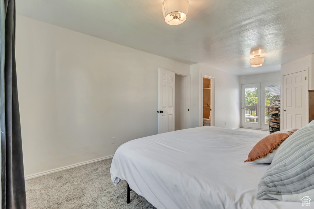 Bedroom with baseboards, carpet flooring, and access to outside