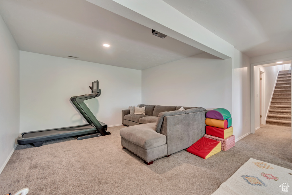 Living room featuring carpet floors, baseboards, and stairs