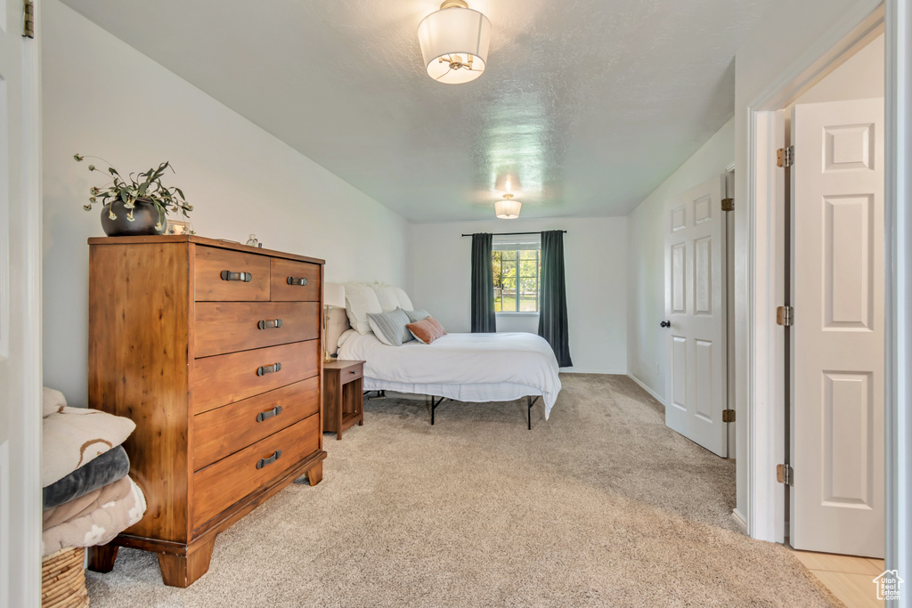 Bedroom featuring light carpet