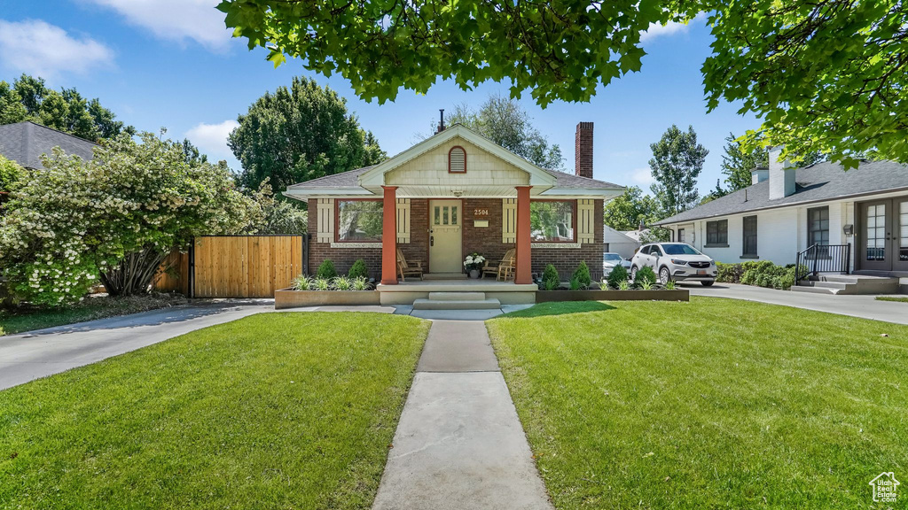 Bungalow-style house featuring brick siding, french doors, and a chimney