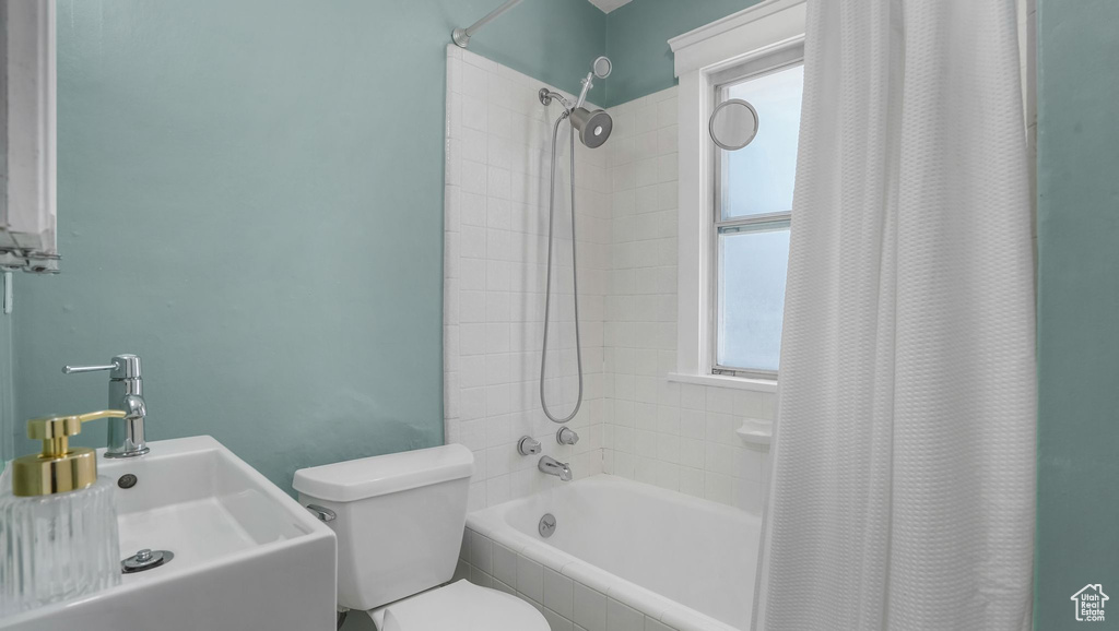 Full bathroom featuring tiled shower / bath, a sink, and toilet