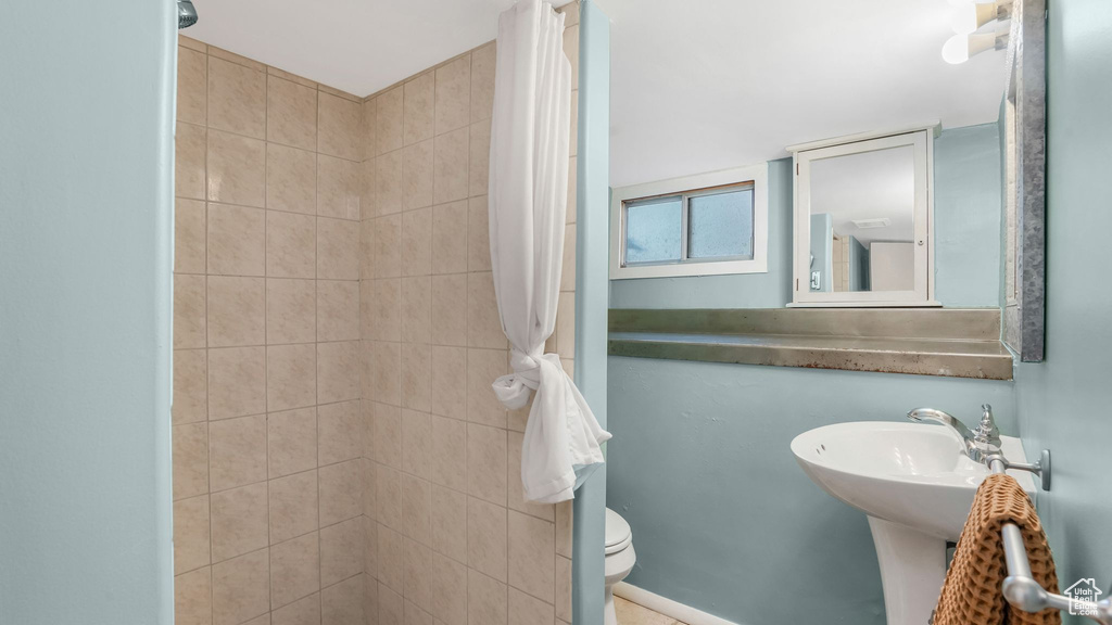 Full bath featuring tiled shower and toilet