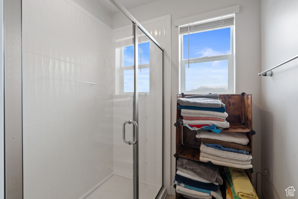 Bathroom featuring a shower stall and plenty of natural light