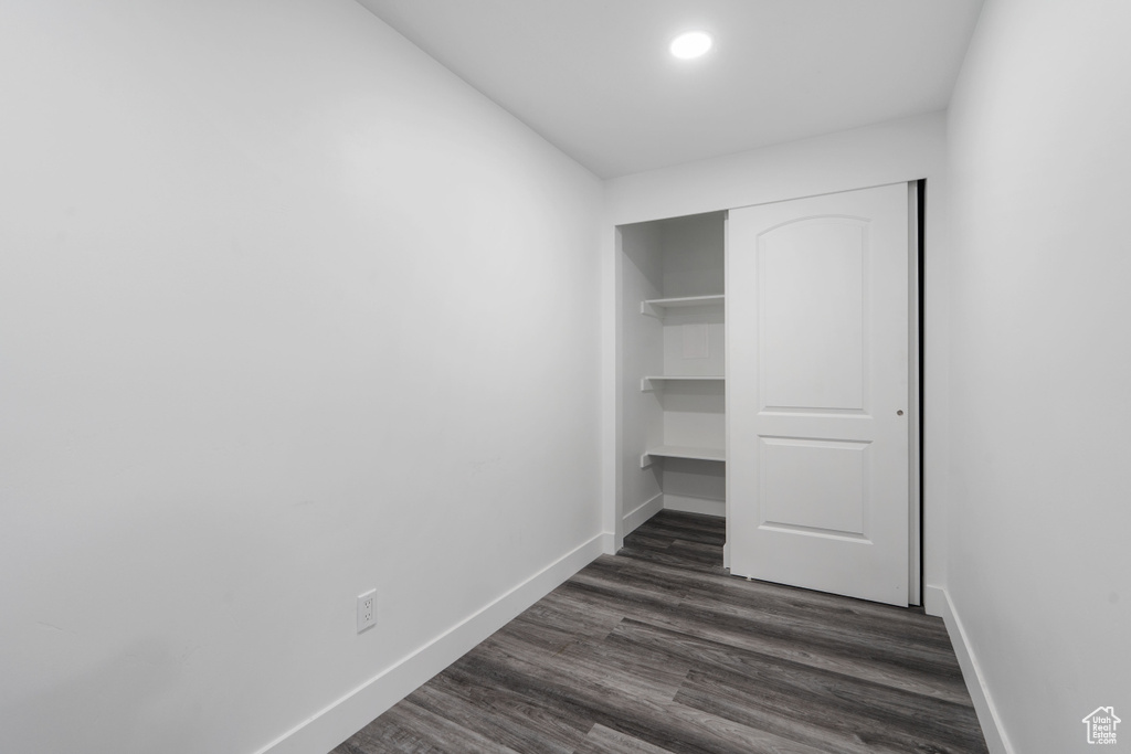 Unfurnished bedroom featuring baseboards, dark wood finished floors, a closet, and recessed lighting