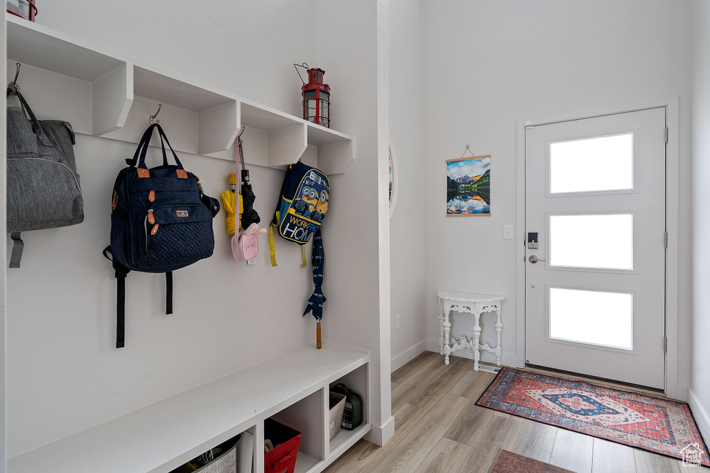 Mudroom featuring light wood-style flooring and baseboards