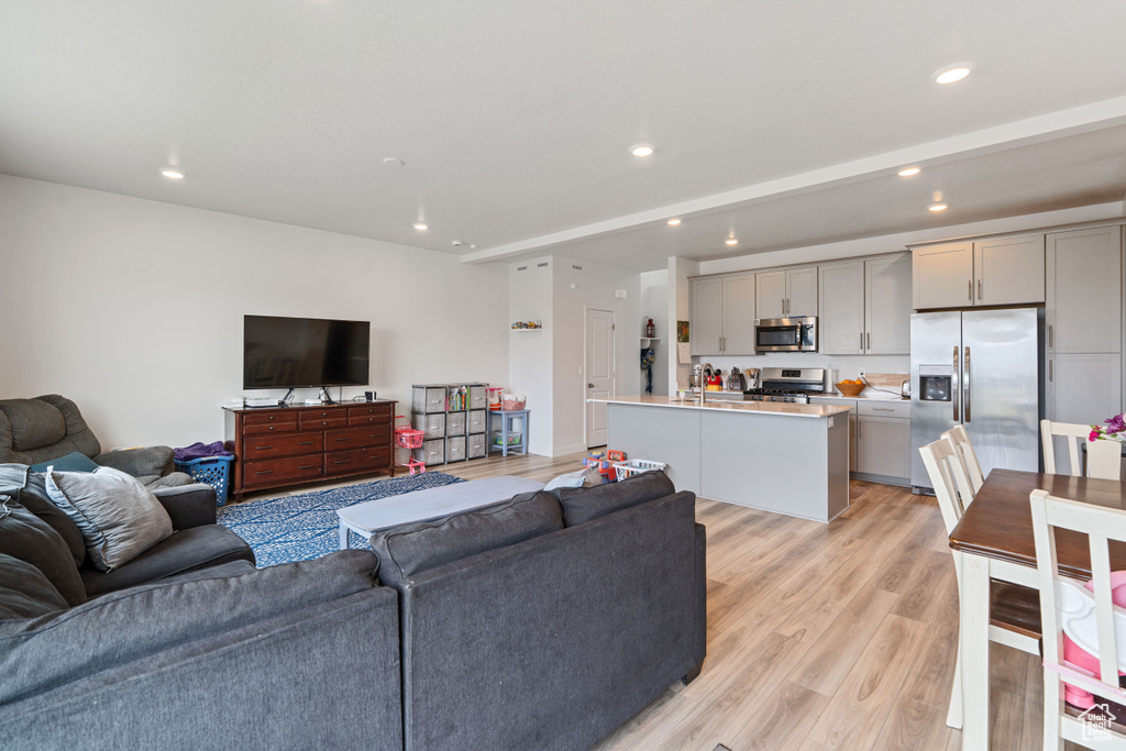 Living room with light wood finished floors and recessed lighting