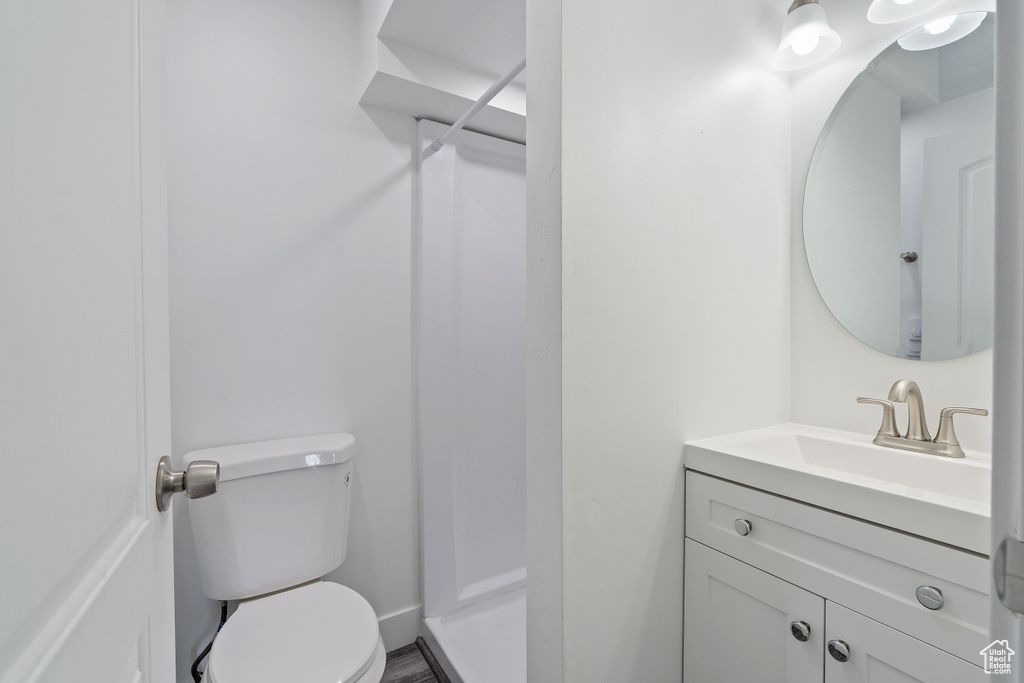Full bath with toilet, vanity, and a walk in shower