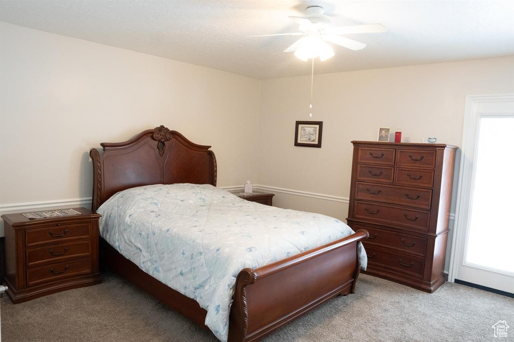 Bedroom featuring multiple windows, light carpet, ceiling fan, and baseboards