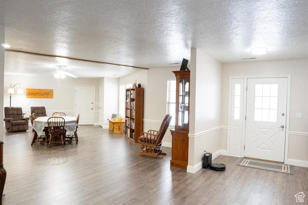 Foyer entrance with a textured ceiling, wood finished floors, ceiling fan, and baseboards