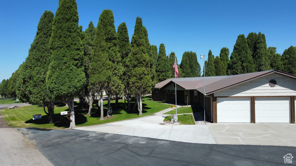 View of front facade featuring concrete driveway, a garage, and a front yard