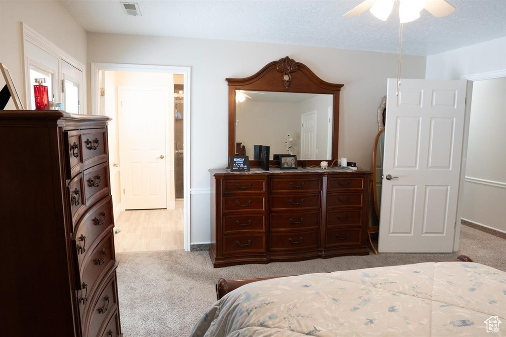 Carpeted bedroom with ceiling fan and baseboards