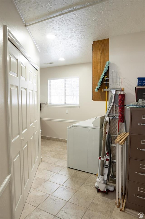 Laundry area with washer / dryer, cabinet space, and a textured ceiling