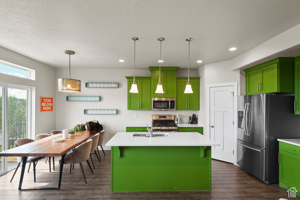 Kitchen featuring appliances with stainless steel finishes, green cabinetry, a sink, a textured ceiling, and recessed lighting