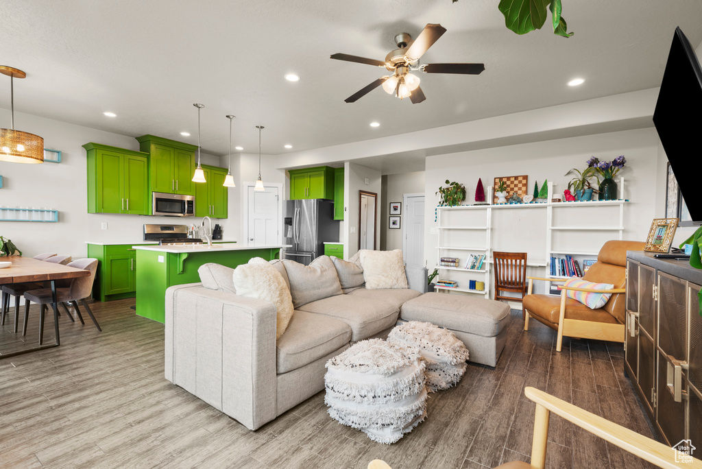 Living area featuring a ceiling fan, light wood-style flooring, and recessed lighting