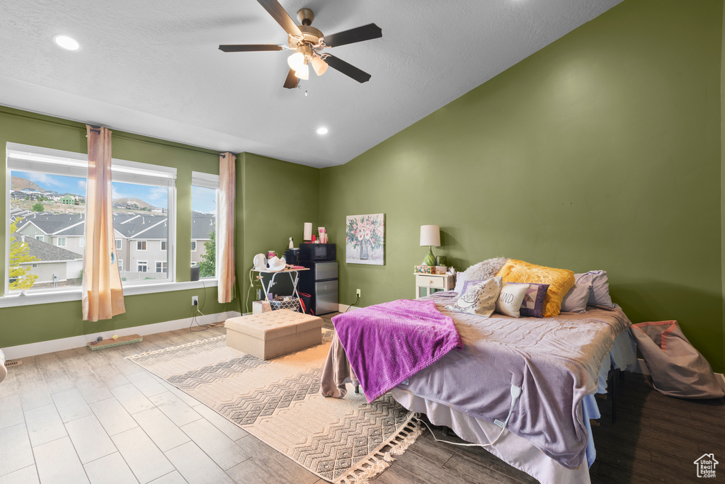 Bedroom featuring lofted ceiling, recessed lighting, baseboards, ceiling fan, and wood finished floors