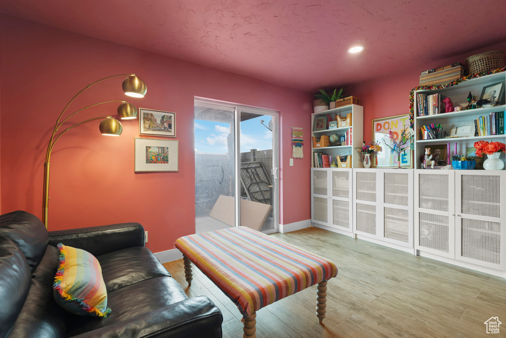 Living room with wood finished floors, baseboards, and recessed lighting