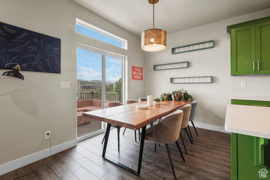 Dining space featuring baseboards and dark wood-style flooring