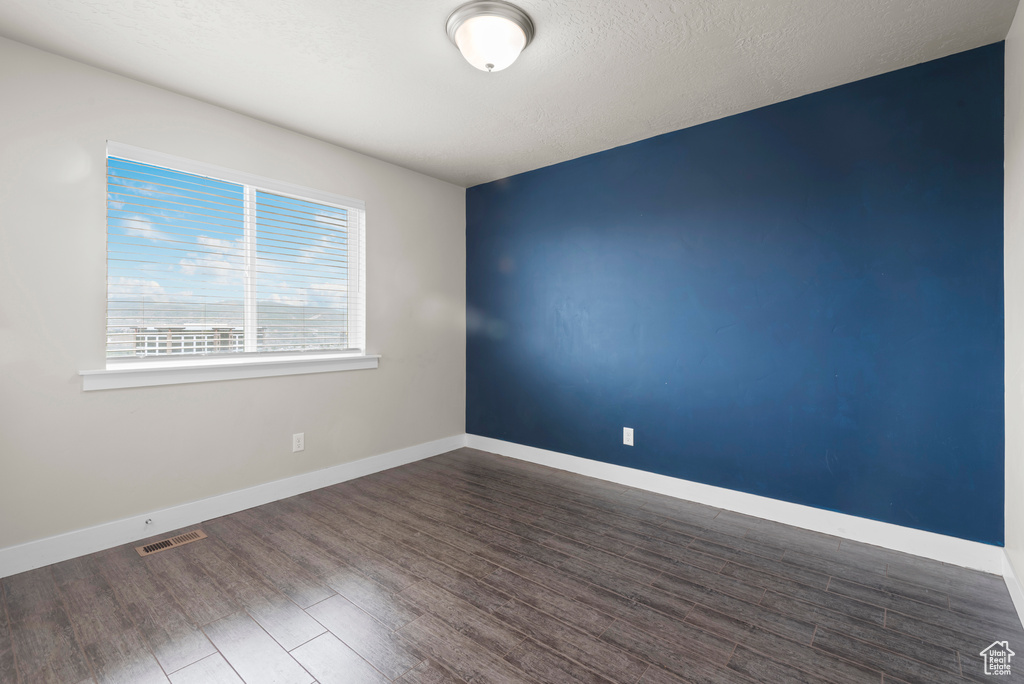 Spare room with dark wood finished floors and baseboards