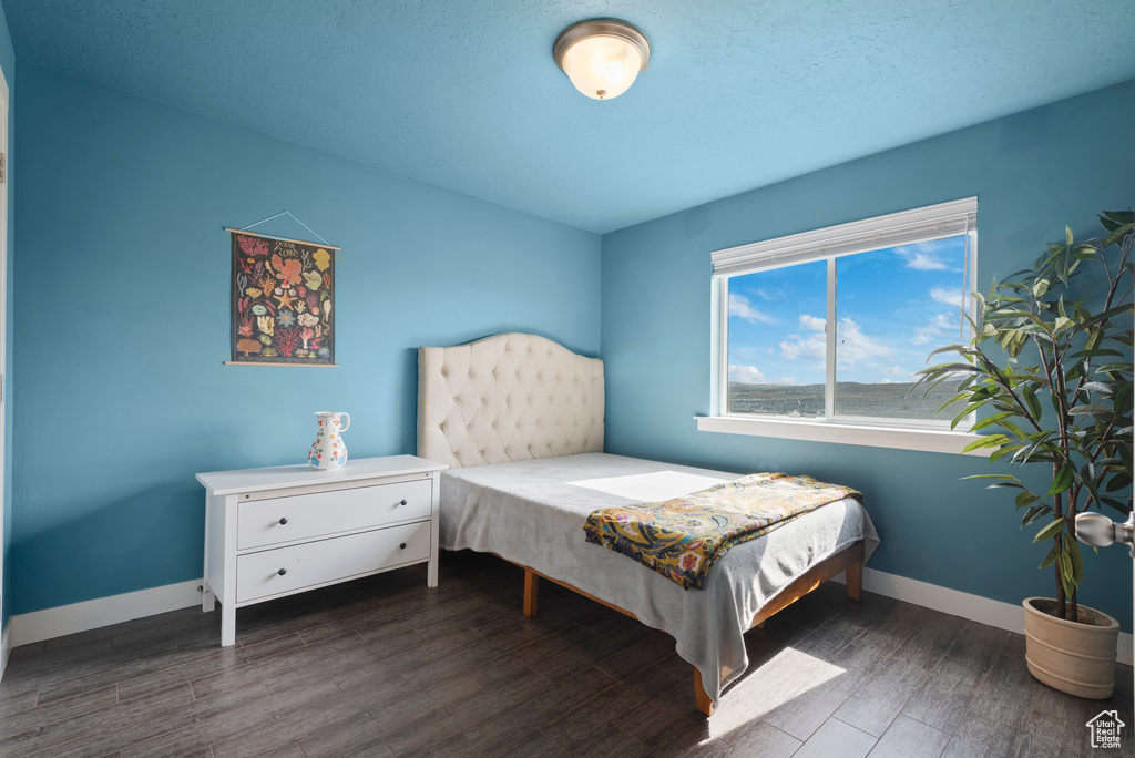 Bedroom with wood finished floors and baseboards
