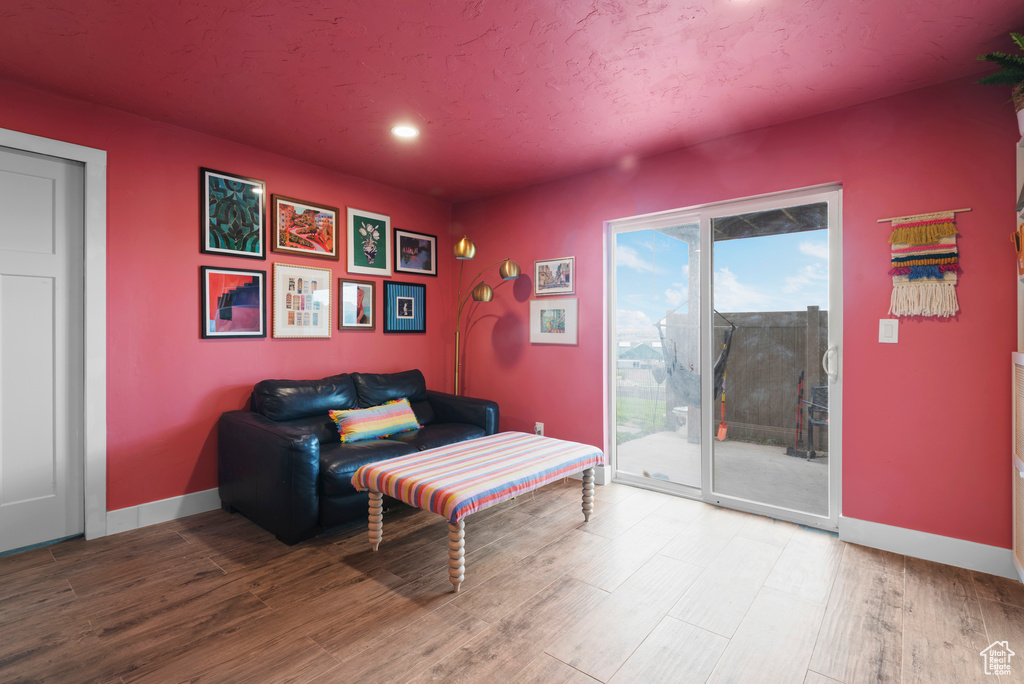 Living area with wood finished floors, baseboards, and recessed lighting