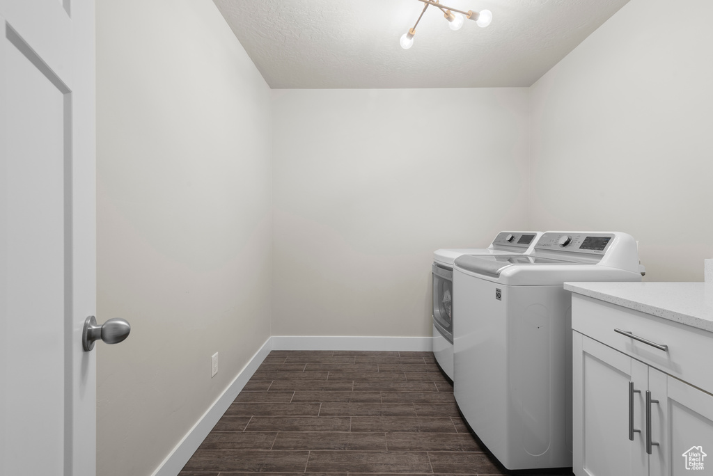 Laundry room with washer and dryer, baseboards, dark wood-style floors, a textured ceiling, and cabinet space