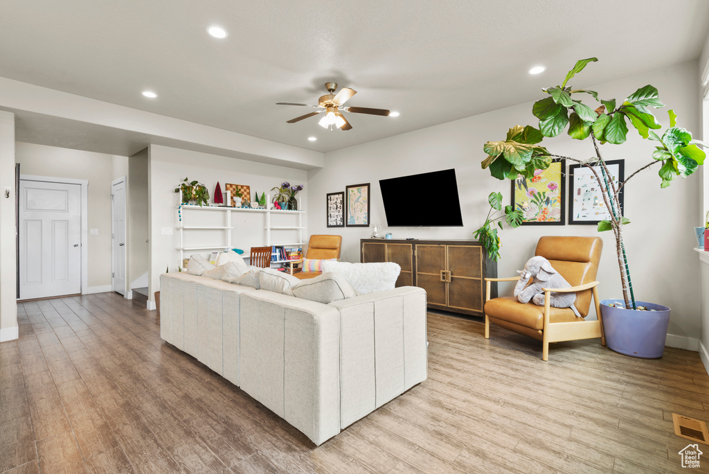 Living area featuring a ceiling fan, recessed lighting, light wood-style flooring, and baseboards
