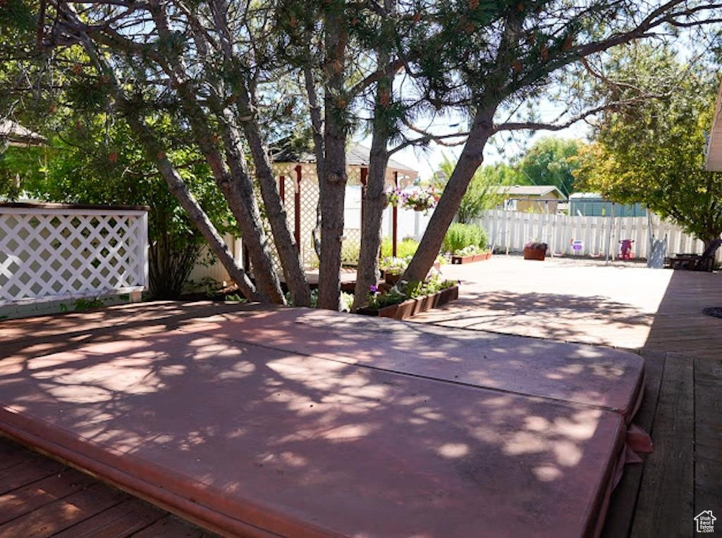 Wooden terrace with a fenced backyard and a patio area