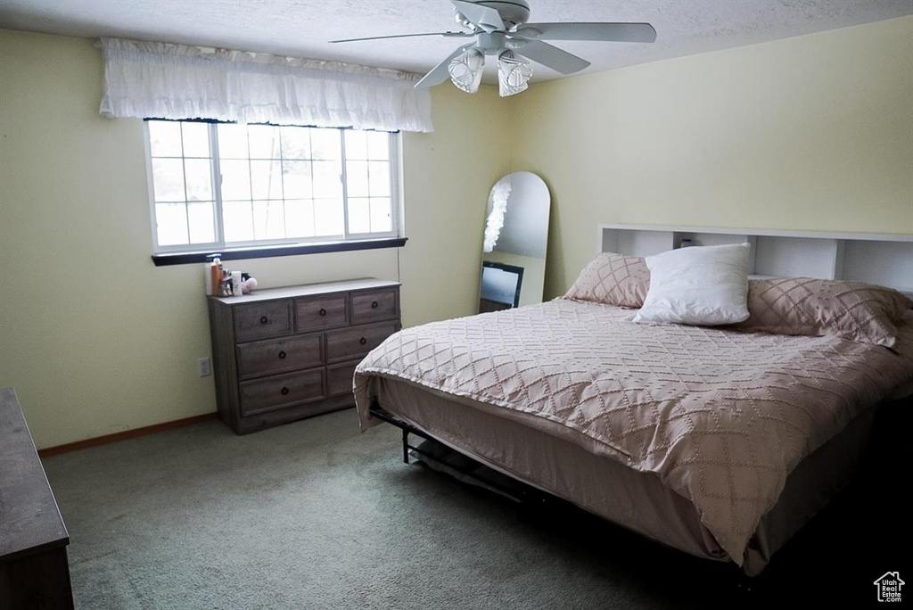 Bedroom with carpet floors, ceiling fan, and baseboards