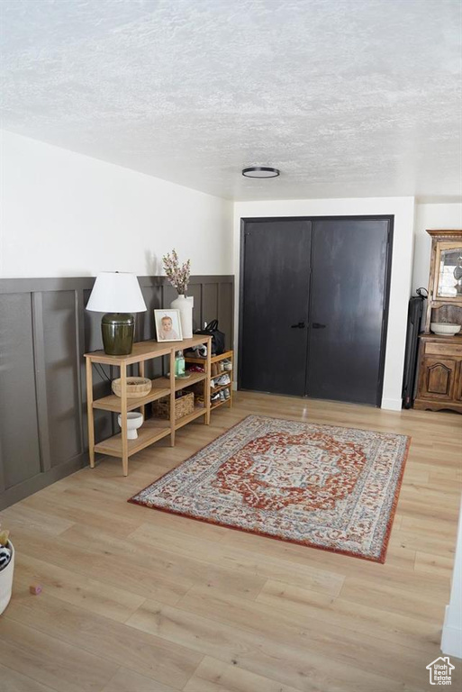 Foyer with wood finished floors and a textured ceiling