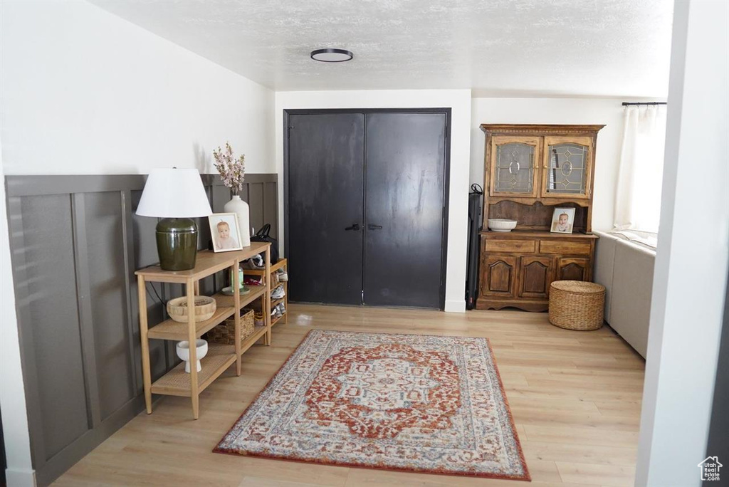 Foyer entrance with wood finished floors and a textured ceiling