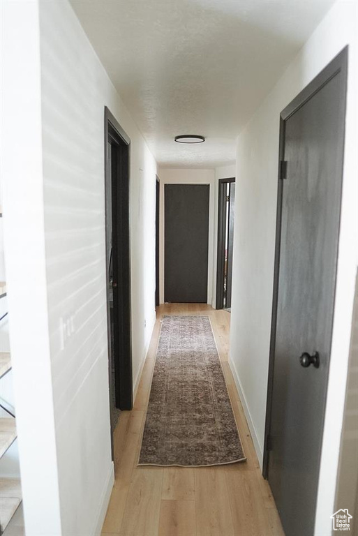 Hallway with light wood finished floors and baseboards