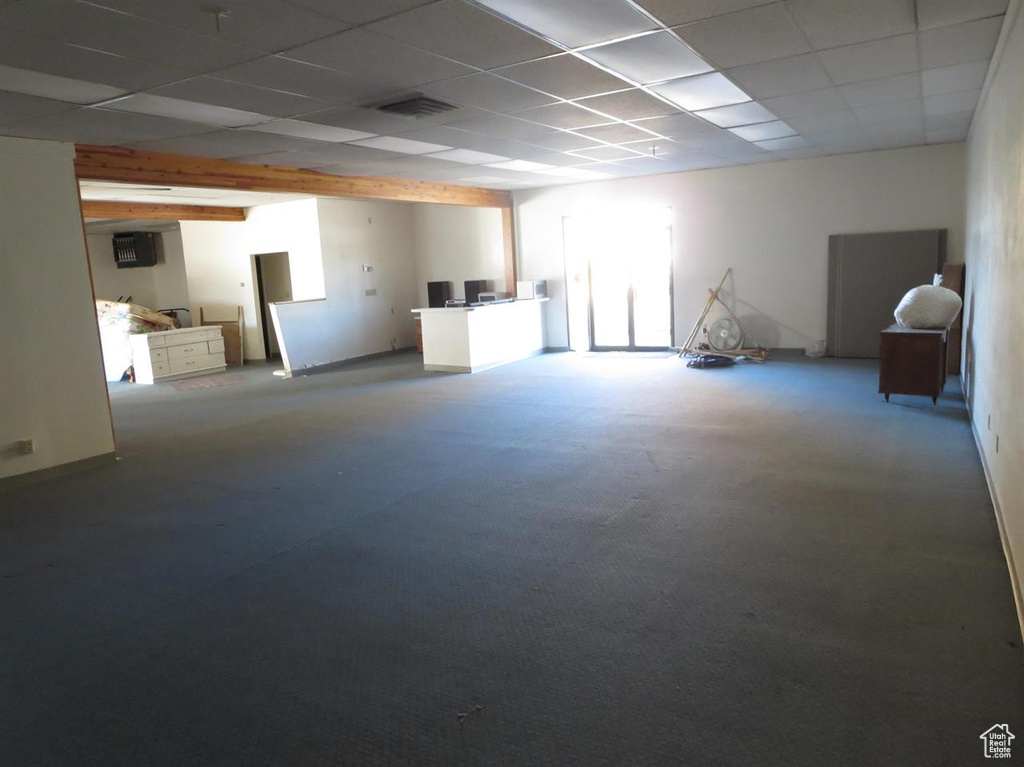 Below grade area featuring a paneled ceiling and carpet flooring