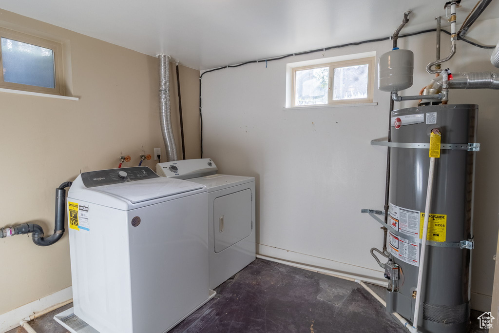 Laundry area featuring strapped water heater and washing machine and clothes dryer