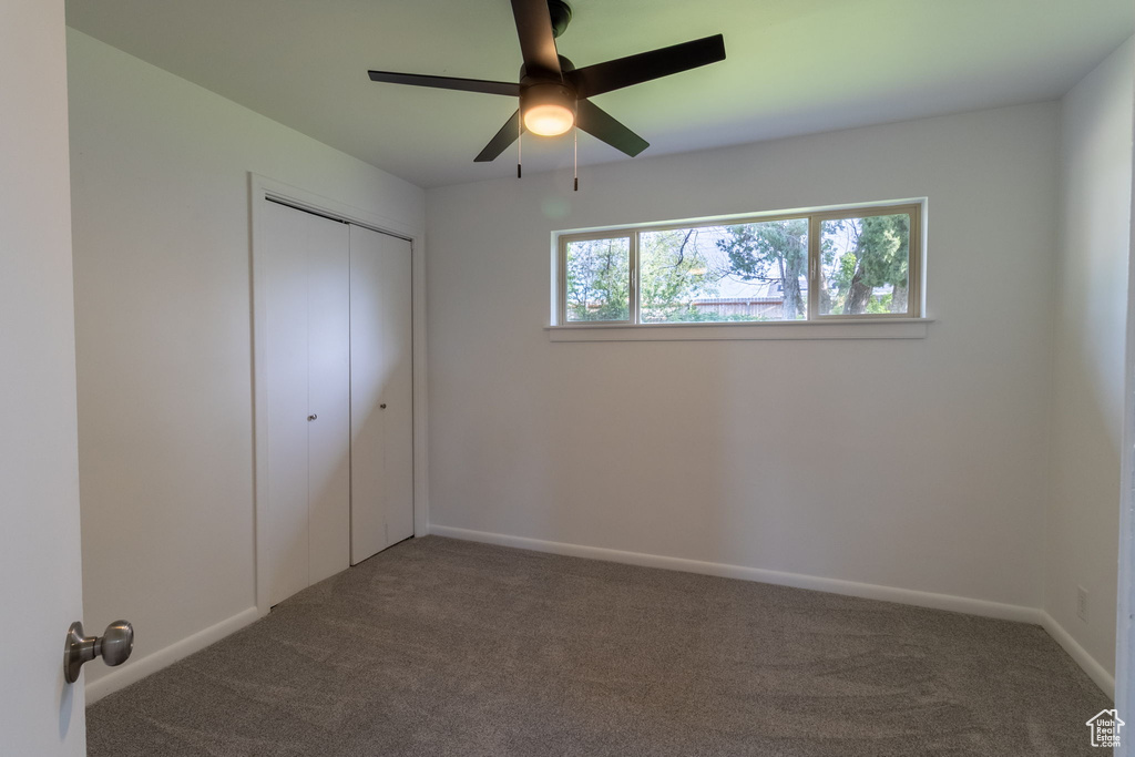 Unfurnished bedroom featuring carpet flooring, a closet, a ceiling fan, and baseboards