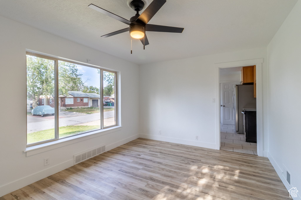 Unfurnished room featuring light wood-style floors, ceiling fan, and baseboards