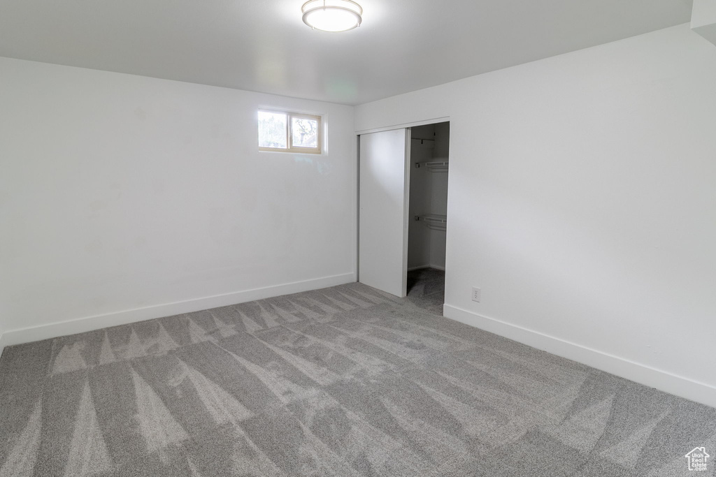Unfurnished bedroom featuring carpet flooring, a closet, and baseboards