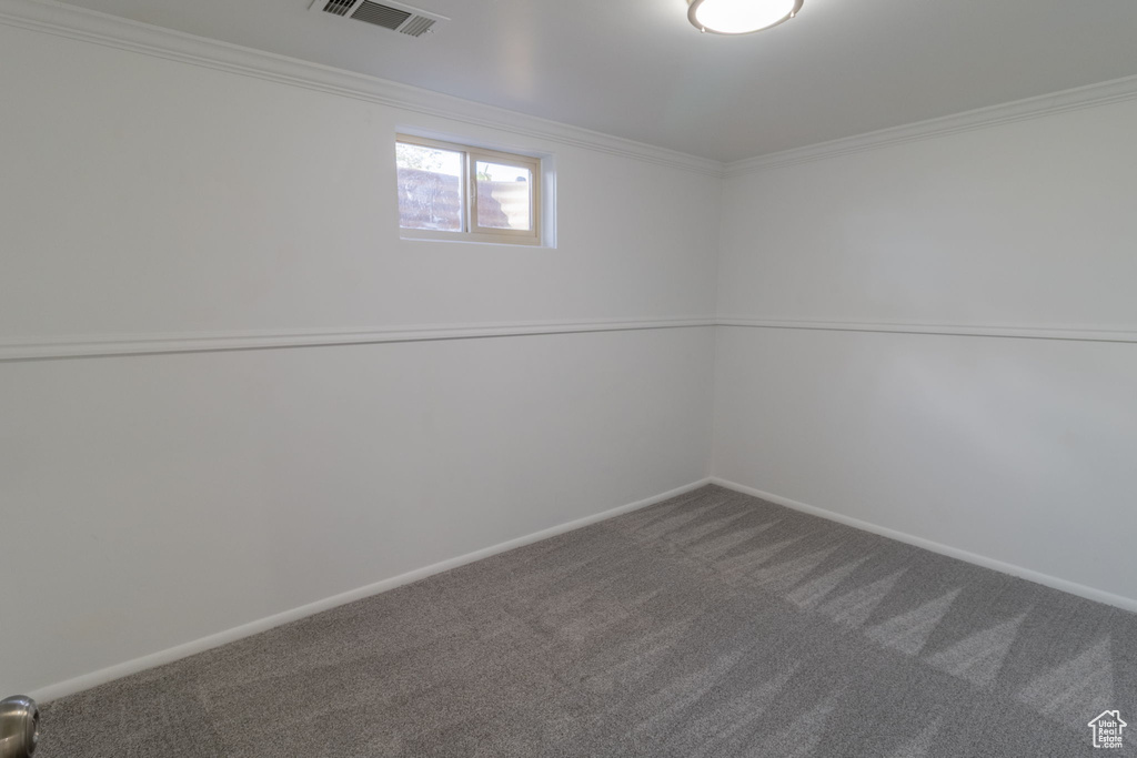 Below grade area featuring carpet, ornamental molding, and baseboards