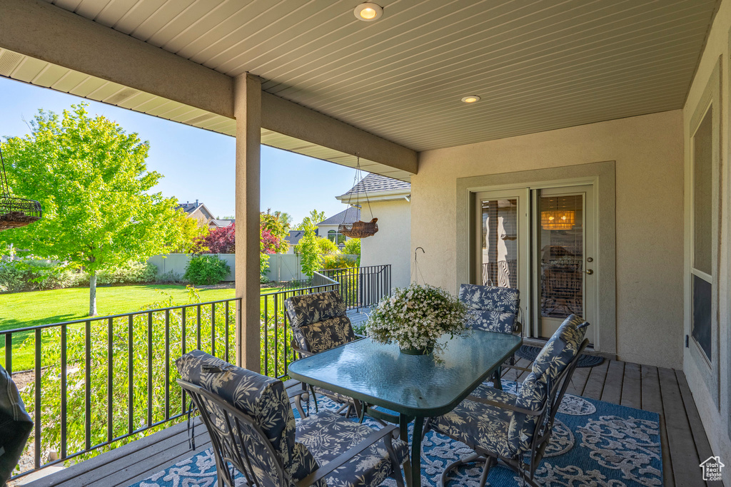 Wooden deck with outdoor dining area and a yard