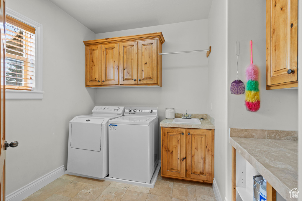 Washroom with cabinet space, separate washer and dryer, and baseboards
