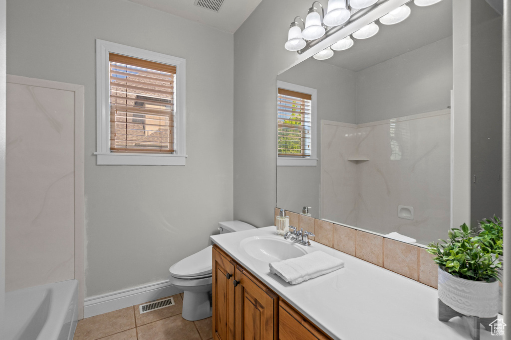 Full bath with tile patterned floors, vanity, toilet, and baseboards