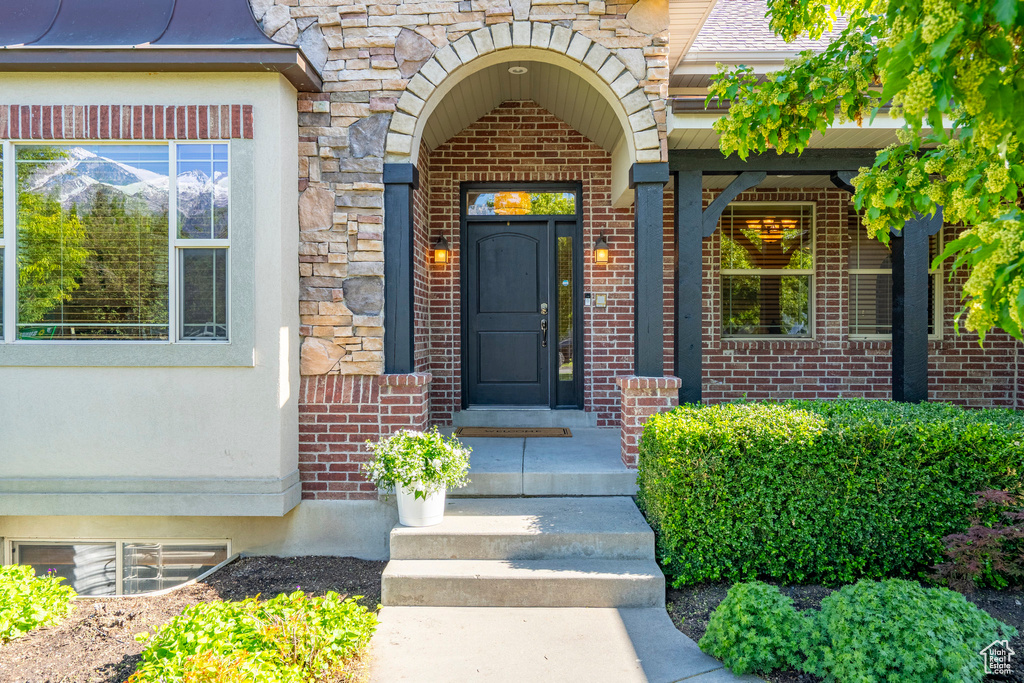 Entrance to property with brick siding and stone siding