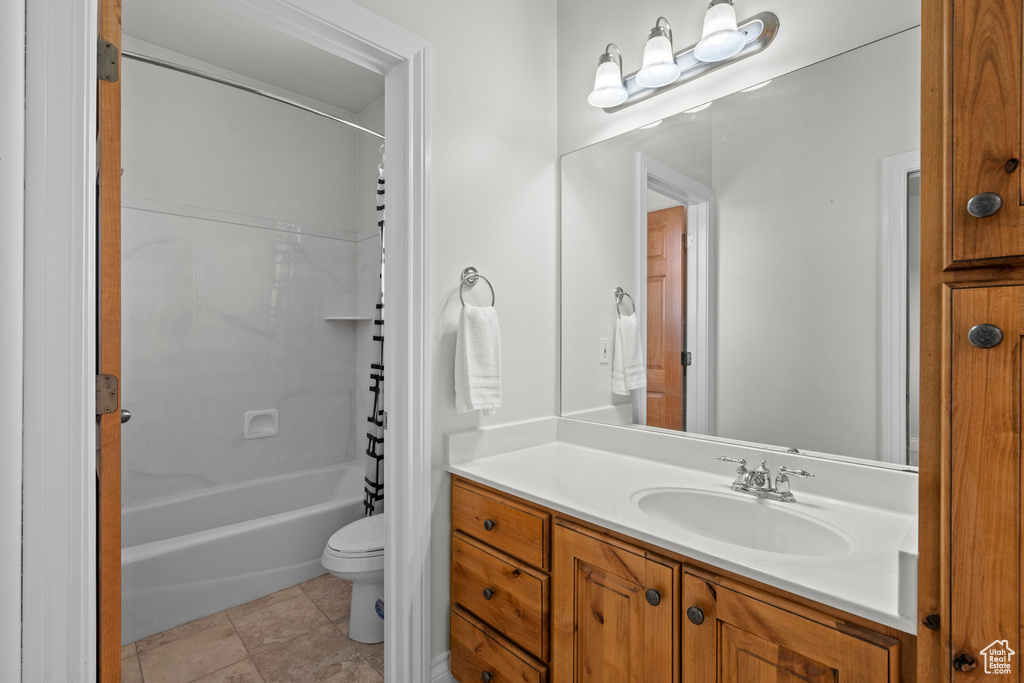 Bathroom with toilet, vanity, and shower / bathtub combination with curtain