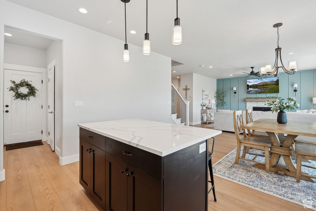 Kitchen featuring light wood finished floors, a center island, open floor plan, a chandelier, and recessed lighting